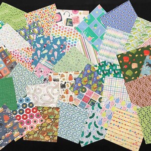 May include: A collection of colorful fabric squares with various patterns, including floral, geometric, and novelty designs. The fabrics feature a range of colors, such as green, blue, pink, and yellow, and are arranged on a black surface.