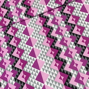 May include: A fabric with a geometric pattern of pink, white, and black triangles. The fabric is folded in half, showing the pattern on both sides.