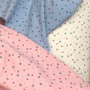 K&ouml;nnte beinhalten: Drei Stoffmuster mit einem kleinen Blumenmuster. Die Muster sind in hellblau, wei&szlig; und rosa.