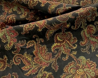 May include: Black fabric with a paisley pattern in shades of red, yellow, and green.