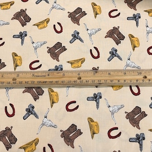 May include: A beige fabric with a repeating pattern of cowboy hats, horseshoes, boots, and skulls. The fabric is perfect for quilting, crafts, and home decor.