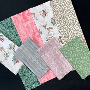 May include: A collection of eight fabric squares featuring various patterns, including floral, geometric, and animal prints. The fabrics are in shades of green, pink, brown, and white.
