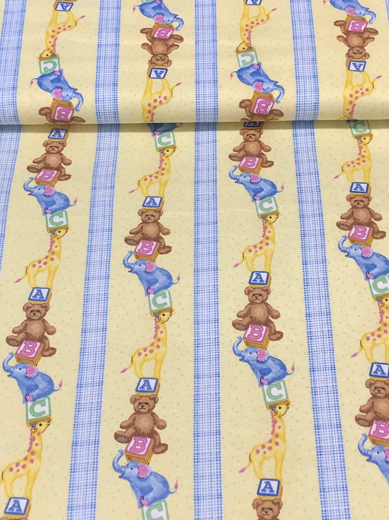 May include: Yellow fabric with a repeating pattern of blue stripes and stacked toy animals. The animals include a giraffe, a teddy bear, and an elephant. Each animal is standing on a block with a letter on it. The letters are A, B, and C.