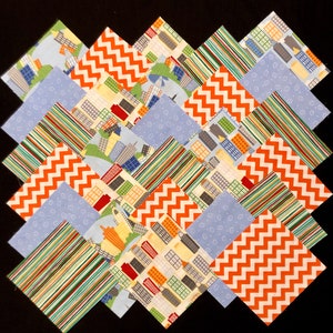 May include: A collection of 16 fabric squares in various patterns, including orange and white chevron, blue and white polka dot, and a cityscape design. The squares are arranged in a staggered pattern, creating a visually appealing display.