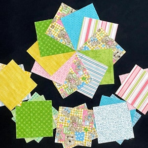 May include: A collection of 12 fabric squares with various patterns, including teddy bears, stripes, polka dots, and checkered designs. The squares are in shades of yellow, green, pink, and blue.