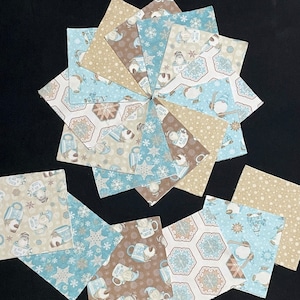 May include: A collection of 12 fabric squares featuring a winter theme with snowflakes, mugs, and snowmen in shades of blue, brown, and beige.