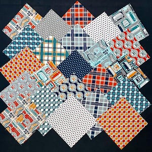 May include: A collection of 20 fabric squares featuring various patterns in shades of blue, red, orange, white, and grey. The patterns include polka dots, plaid, and geometric designs. Some squares feature text that reads "Dream On" and "Run Away Again".