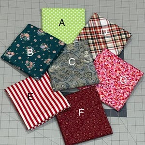 May include: Seven fabric swatches in various patterns and colors are arranged in a circular pattern. The swatches include polka dots, floral, plaid, stripes, and geometric designs. Colors include green, red, pink, and blue.