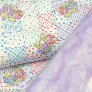 May include: A white fabric with a patchwork design featuring pink, blue, and white checkered patterns, hearts, stars, and small teddy bears. The fabric is folded over a solid lavender fabric.