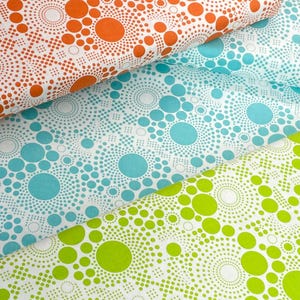 May include: Three fabric swatches with a white background and a pattern of different sized circles. The circles are filled with orange, blue, and green colors. The circles are made up of smaller dots.