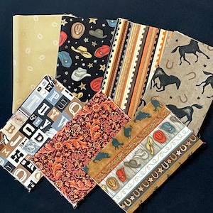 May include: A collection of six fabric squares with various western-themed patterns. The patterns include cowboys, horseshoes, hats, stars, and letters. The fabrics are in shades of brown, tan, black, and red.