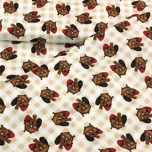 May include: A white fabric with a brown and white checkered pattern. The fabric is covered in a repeating pattern of brown beavers wearing red hats. The beavers are holding a stick in their paws.