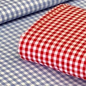 May include: Two pieces of checkered fabric, one blue and white, and the other red and white. The red and white fabric is folded on top of the blue and white fabric.