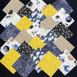 以下が含まれることがあります： 宇宙をテーマにした16個の布の正方形のセットです。正方形は、黄色、青、白、黒など、さまざまな色で構成されています。布の正方形には、惑星、星、ロケット、雲など、さまざまな宇宙をテーマにしたデザインが施されています。