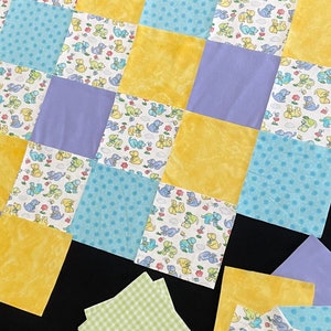 May include: A patchwork quilt with a variety of fabrics, including yellow, blue, and purple. The quilt is made up of squares with different patterns, including polka dots, stripes, and animal prints.
