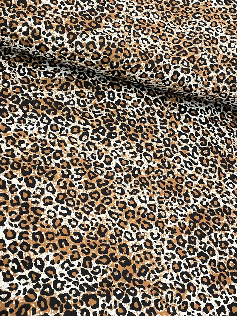 May include: Brown, black, and white leopard print fabric with a subtle distressed look.