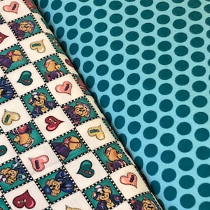 May include: Two fabric swatches, one with a white background and a repeating pattern of teddy bears wearing hats and hearts, and the other with a teal background and a repeating pattern of teal circles.