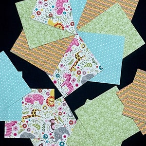 May include: A collection of ten fabric squares featuring various patterns, including animal prints, polka dots, and zigzags. The squares are in shades of green, blue, pink, and yellow.