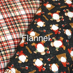 May include: Two fabric swatches, one red and black plaid flannel and one black flannel with a repeating pattern of gnomes holding axes and logs.