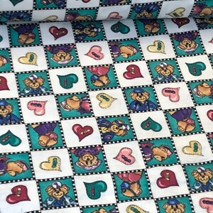 May include: A white fabric with a repeating pattern of teddy bears wearing sailor hats, hearts, and green squares. The fabric has a checkered pattern.