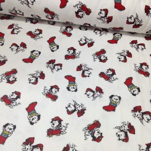 May include: White fabric with a repeating pattern of cartoon Dalmatian dogs and red fire truck designs. The dogs are black and white with red hats and are interspersed with red Christmas stockings. The fabric is rolled up in the image.