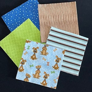 May include: Four fabric squares, one with a blue polka dot pattern, one with a green and white checkered pattern, one with brown and white stripes, and one with a blue background and a repeating pattern of brown dogs with bone-shaped toys.