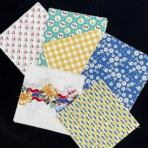 May include: Six fabric squares with different patterns. The patterns include yellow and blue gingham, white daisies on a blue background, yellow lemons on a blue background, a white background with a red, white, and blue floral border, yellow cherries on a white background, and yellow daisies on a light blue background.