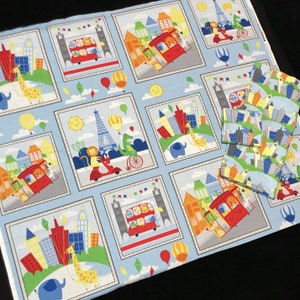 May include: A blue and white fabric with a repeating pattern of cityscapes, animals, and transportation. The pattern includes red double-decker buses, giraffes, elephants, and scooters. The fabric is perfect for quilting, crafts, and home decor.