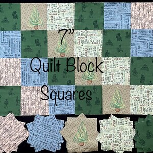 May include: A 7-inch quilt block with a green, beige, and blue fabric pattern. The block is made up of nine squares, each with a different pattern. The fabric patterns include a repeating pattern of a cabin, a lake, a river, and the words "cabin lodge woods". The block is labeled "Quilt Block Squares".