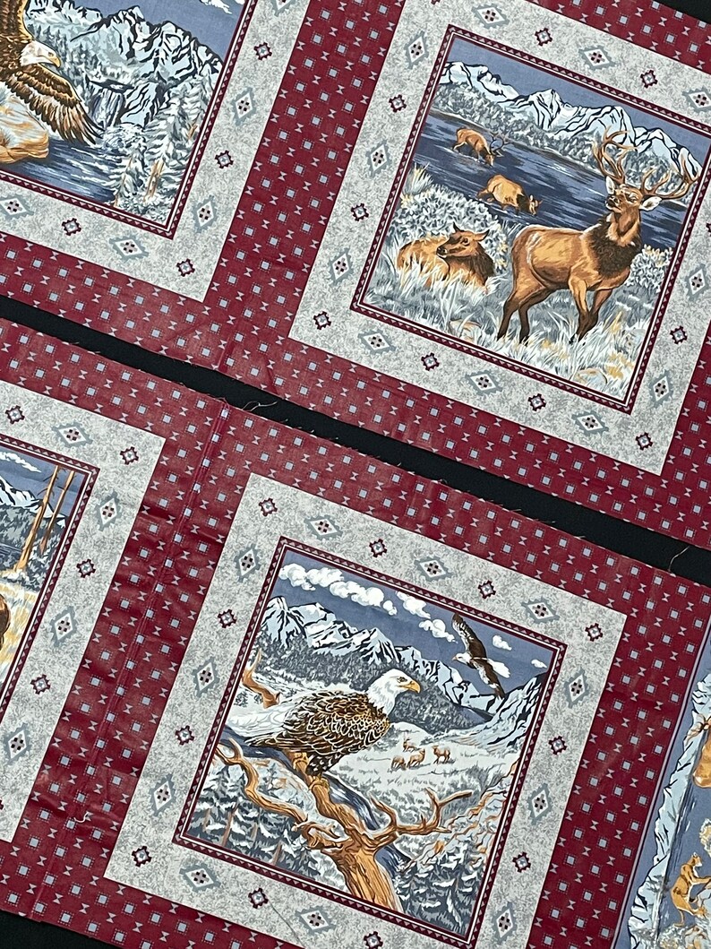 May include: A set of three fabric squares with a red and white patterned border. Each square features a different nature scene with a bald eagle, a deer, and a mountain range.