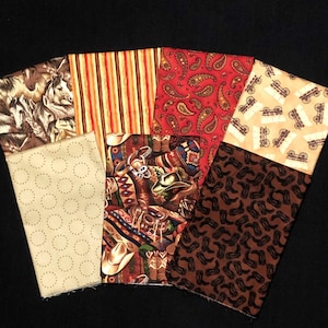 Puede incluir: Un conjunto de seis cuadrados de tela con varios patrones de temática western. Los patrones incluyen paisley, rayas, caballos, botas y ruedas de carro. Las telas son en tonos de marrón, beige, rojo y crema.
