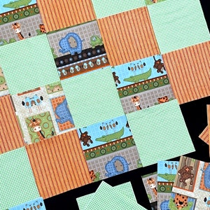 May include: A patchwork quilt with a green, white, and brown checkered pattern. The quilt is made up of squares with different animal prints, including elephants, giraffes, and crocodiles. The quilt is laid out on a black surface.