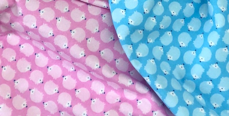 May include: Two fabric swatches with a repeating pattern of white hedgehogs on a pink and blue background.