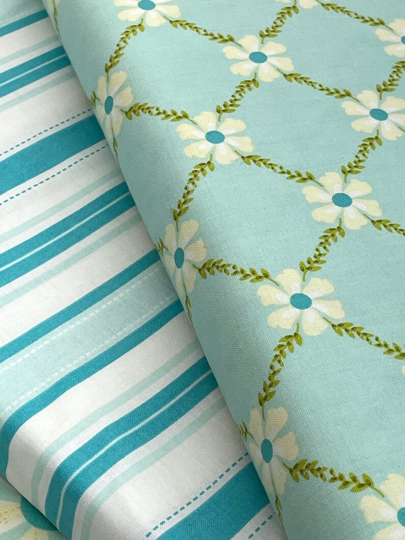 May include: Two fabric swatches, one with a blue and white striped pattern and the other with a light blue background and a white floral pattern.