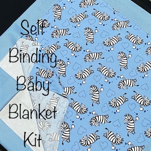 Op de afbeelding: Een zelfbindende babydekenset met een blauwe achtergrond en een zebraprint. De tekst "Self Binding Baby Blanket Kit" is op de stof gedrukt.