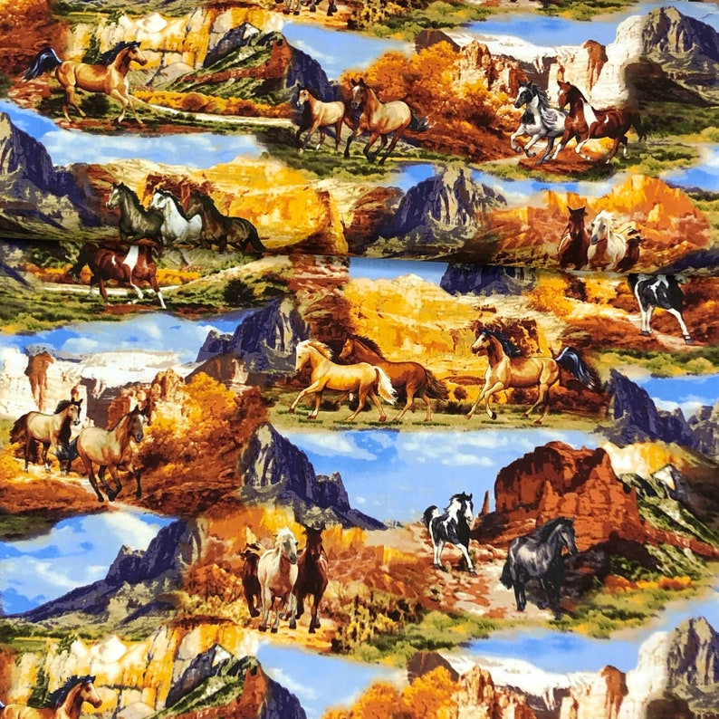 May include: A colourful fabric featuring a repeating pattern of horses running through a desert landscape with mountains and canyons. The horses are brown, white, and black, and the background is a mix of brown, orange, and blue.