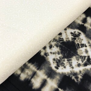 May include: Two fabric swatches, one with a white swirl pattern on a cream background and the other with a black and white tie-dye pattern.