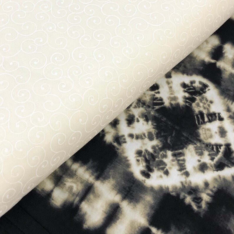 May include: Two fabric swatches, one with a white swirl pattern on a cream background and the other with a black and white tie-dye pattern.