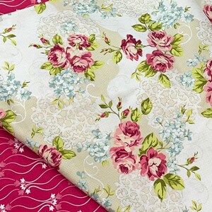 Puede incluir: Dos piezas de tela con patrones florales. Una tela es de fondo beige con rosas rosas y hojas verdes. La otra tela es de fondo rojo oscuro con diseños florales blancos.