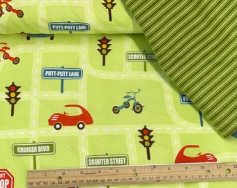 May include: Green fabric with a repeating pattern of cars, tricycles, traffic lights, and street signs. The fabric has a light green background with white lines and a dark green border. The fabric is printed with the words "Putt-Putt Lane", "Cruiser Blvd", "Scooter Street", and "Don't Stop Playing".