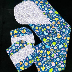 May include: A set of four blue fabric squares with a white polka dot pattern. The squares are decorated with a colorful floral and animal print featuring birds, squirrels, and flowers. The squares are perfect for a variety of craft projects.