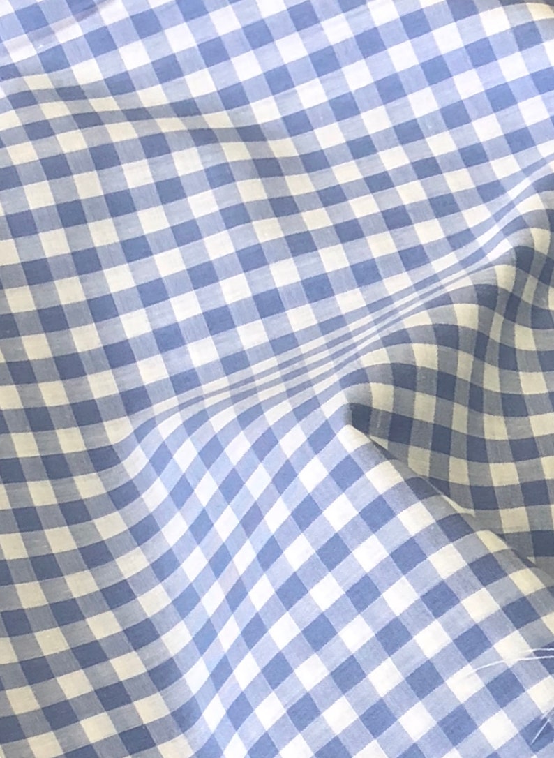 May include: Blue and white gingham fabric with a subtle texture. The fabric is folded and has a slight wrinkle.
