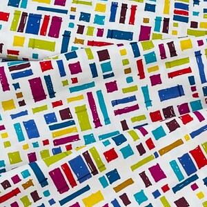 May include: White fabric with a repeating pattern of colorful rectangles and squares. The pattern is abstract and geometric.