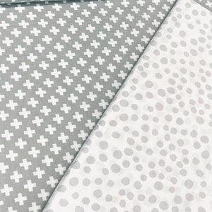 May include: Two fabric swatches, one with a white plus sign pattern on a grey background, and the other with a white polka dot pattern on a grey background.