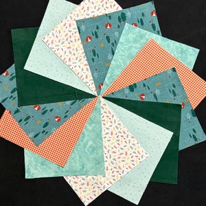 May include: A circular quilt block composed of various fabric patterns. The design includes teal fabric with a forest print, orange gingham, and fabrics with leaf and dot patterns. Dark green fabric forms the center and some sections.