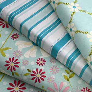 May include: Four different fabric swatches in a light blue color scheme. The top swatch has a white and blue striped pattern. The second swatch has a white floral pattern on a light blue background. The third swatch has a white and pink floral pattern on a light blue background. The bottom swatch has a red and pink floral pattern on a light blue background.