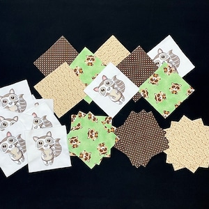 May include: A collection of fabric squares featuring a raccoon design. The squares are in various colors and patterns, including brown, green, and white. Some squares have a polka dot pattern, while others have a floral design. The squares are perfect for quilting, crafting, or other sewing projects.