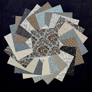 Könnte beinhalten: Eine Sammlung quadratischer Stoffmuster, die in einem kreisförmigen Fächermuster angeordnet sind. Die Stoffstücke weisen verschiedene Muster auf, darunter Blumen-, Damast- und geometrische Designs in einer Farbpalette aus Hellblau, Creme, Beige, Braun und Schwarz.