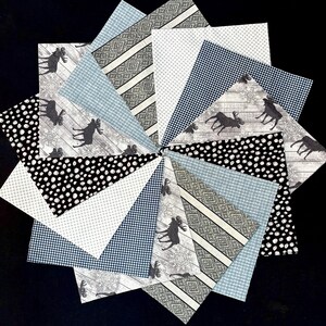 May include: A circular arrangement of fabric swatches in various patterns. Designs include black and white polka dots, blue gingham, gray stripes, and a wood-grain pattern with moose silhouettes. The swatches are arranged on a black background.