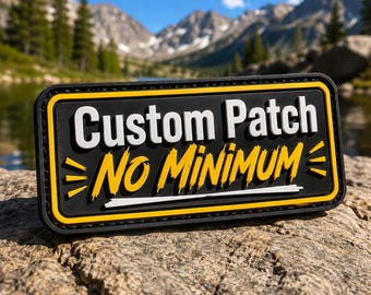 May include: A rectangular black patch with a yellow border featuring the white text Custom Patch and the yellow text NO MINIMUM. The design includes yellow graphic accents on the sides and a white horizontal line beneath the yellow text.